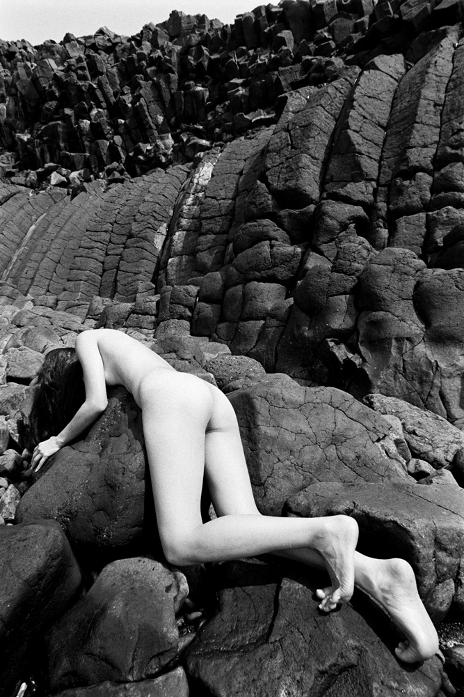 Black and white volcanic figure study photograph, with sculptural form emerging through dramatic tonal contrast.